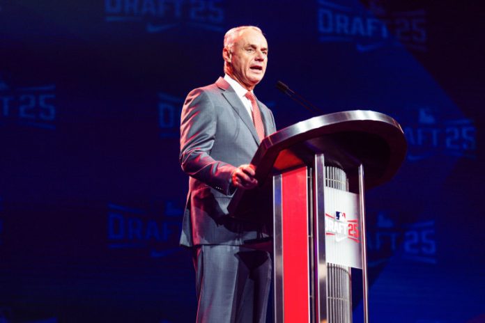 Major League Baseball owners made their long-expected salary cap proposal to the players’ association on Thursday, a system the union has vowed never to accept, setting the sides on course for a confrontation that threatens the 2027 season and perhaps beyond.
Baseball owners hadn’t proposed a firm cap since 1994. Their effort prompted a 7 1/2-month strike that forced the cancellation of the World Series for the first time in 90 years.
MLB’s proposal would cap spending in 2027 at $245.3 million, using figures for luxury tax payrolls that include benefits and the pre-arbitration bonus pool, and establish a payroll floor of $171.2 million. The Los Angeles Dodgers, baseball’s biggest spenders, had a $415.2 million payroll on opening day this year — around $170 million over the proposed cap.
Owners said they would discuss a phase-in schedule that would give teams like the Dodgers time to comply with the cap and an escrow system with the union as part of a proposed seven-year deal, that all current contracts would remain guaranteed and there would be no prohibition of guaranteed contracts under the cap system.
MLB said it would centralize local media revenue from the 30 teams equally and give players a 50-50 split as part of a proposal that would eliminate the current revenue-sharing plan among the clubs.
Major League Baseball Commissioner Rob Manfred.Matthew Grimes Jr. / Atlanta Braves via Getty Images file
“Our salary cap and floor proposal levels the playing field while sharing baseball revenue with the players 50/50 as we grow the game together,” MLB spokesman Glen Caplin said in a statement. “Further, by sharing media revenue equally as part of our proposal, we can address another top fan concern of local TV blackouts.”
Baseball’s current five-year deal, agreed to in March 2022 after a 99-day lockout, expires Dec. 2. While a lockout next winter is expected, talks are not likely to intensify until late February or early March 2027, when the possibilities of losing regular-season games and revenue near. If regular-season games are lost, negotiations may become a standoff of which side can tolerate the most economic loss.
Based on 2026 opening day figures, eight teams would have to cut payroll to get under the cap. The teams over are the two-time reigning World Series champion Dodgers, New York Mets ($379.2 million), New York Yankees ($339.6 million), Toronto ($319.5 million), Philadelphia ($315.2 million), Boston ($263.7 million), San Diego ($260.1 million) and Atlanta ($247.9 million).
Twelve teams would be required to increase payroll by a total of $617 million based on 2026 numbers: Miami ($81.8 million), Cleveland ($95.7 million), Tampa Bay ($108.2 million), the Chicago White Sox ($108.6 million), St. Louis ($114.4 million), Washington ($119.1 million), Pittsburgh ($122.6 million), Minnesota ($125.6 million), Milwaukee ($130.9 million), the Athletics ($139.2 million), Colorado ($142.2 million) and Cincinnati ($148.8 million).
Owners and the union agreed to a luxury tax in 2003 designed to slow spending, but teams feel it has had little or no impact on the Dodgers and Mets in recent years. The last small-market MLB club to win a World Series was Kansas City in 2015, although Cleveland, Tampa Bay and Milwaukee all lead their divisions as of Thursday, while the Mets and Red Sox are in last place.
MLB said its revenue has grown by 247% since 2003 and player payroll has increased by 149% in that span.
Management gave the union its latest plan during a bargaining session at the commissioner’s office, one day after the union made its economic proposal. Owners say a cap is needed to improve competitive balance and restrain wealthy teams from assembling starrier rosters than their smaller-market brethren.
Players want expanded free agency and salary arbitration rights along with almost doubling the major league minimum, increasing the money high-revenue teams share with the less-wealthy clubs and establishing penalties for teams that drop below payroll floors.
Aaron Judge of the U.S. leads teammates onto the field before game against Venezuela in the World Series of Baseball in Miami on March 17.Megan Briggs / Getty Images file
Other U.S. major sports leagues operate under a cap. The NBA had a cap in its initial season in 1946-47, then dropped that and began its modern version in 1984-85. NFL players and owners adopted a cap for the 1994 season, and the NHL did so in 2005-06 after a lockout wiped out the entire 2004-05 season.
The Dodgers shattered MLB’s spending record with a combined $515 million in payroll and luxury tax last year en route to their second straight World Series title. Los Angeles’ total was seven times the $68.7 million payroll of the Marlins, the lowest-spending team, and more than the payrolls of the bottom six clubs combined.
Players say a cap would hurt them and enrich owners, and they say they will never agree to one. Without a cap, MLB stars have landed lucrative, guaranteed contracts that outpace what the biggest stars in other U.S. sports leagues make. Juan Soto’s $765 million, 15-year contract with the Mets is believed to be the biggest ever in team sports and is far greater than the largest deals in the NFL (Patrick Mahomes at $450 million over 10 years) and NBA (Jayson Tatum at $314 million over five years).
MLB’s last salary cap proposal in 1994 offered players a 50-50 split of revenue in a system that would have forced teams to maintain payrolls of 84%-110% of the average. Salary arbitration would have been eliminated and the threshold for free agency would have been lowered from six years’ major league service to four — with the provision that a player’s former club could match any offer until he had six years.
MLB’s offer came on June 14 that year, and players struck on Aug. 12. MLB withdrew the cap proposal the following Feb. 6 after pressure by the National Labor Relations Board. The strike ended on March 31 after U.S. District Judge Sonia Sotomayor — now a Supreme Court justice — issued an injunction restoring the work rules of the expired labor contract. Two days later, owners accepted the union’s offer to return to work without an agreement. A deal wasn’t reached until 1997.